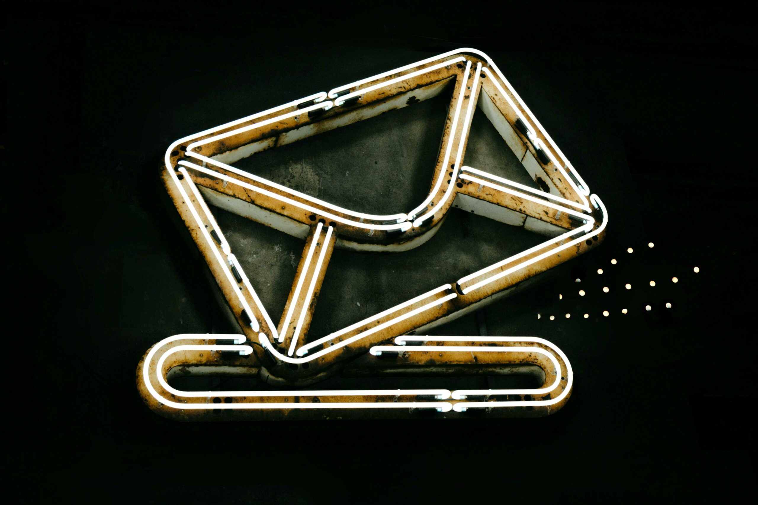 pexels-photo-5605061-5605061 A glowing neon envelope symbol against a black background, conveying messaging or email concept.